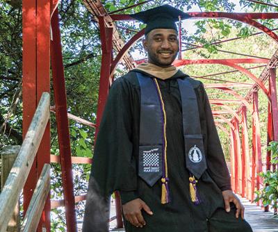 Student veteran in cap and gown with Veteran tribute stole 